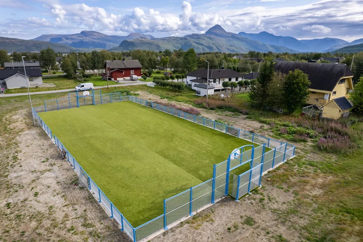 Blå ballbinge med miljøvennlig kunstgress som underlag