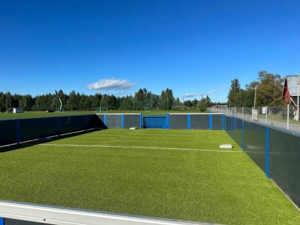 Miniballbinge med grå, tette paneler og blå stolper.