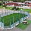 Blå multisportbinge med ballfangernett og kunstgress