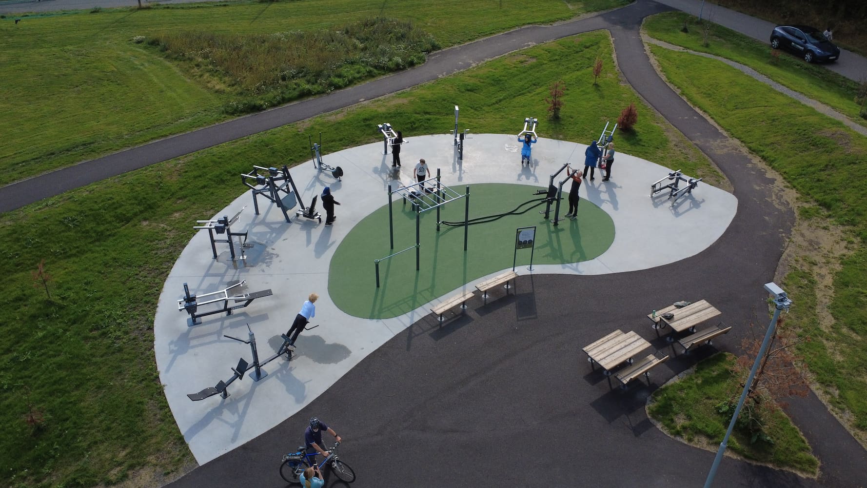 Utendørs treningspark med styrkeapparater med justerbar vekt, kombinert med kroppsvektstrening.